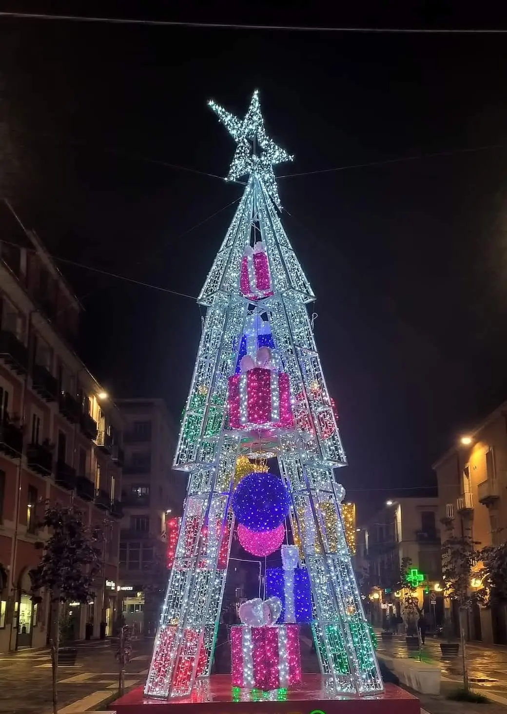 Albero di Natale luminoso a piramide con pacchi regalo di luce