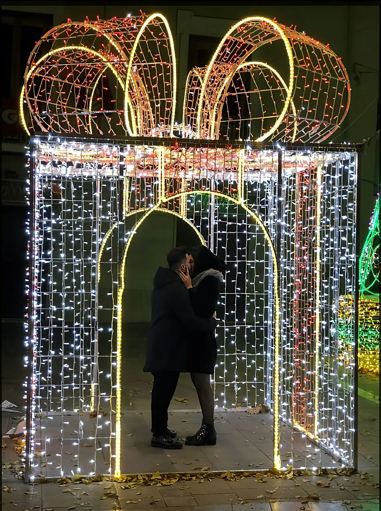 Coppia che si bacia dentro un grande pacco regalo luminoso
