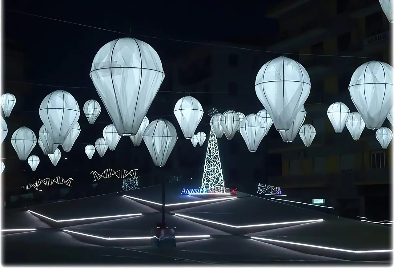 Decine di mongolfiere bianche luminose sospese sopra una piazza