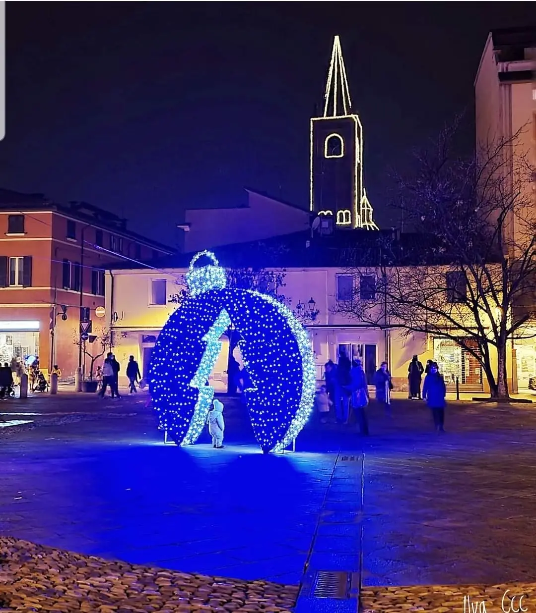 Grande sfera blu attraversabile in una piazza con il campanile