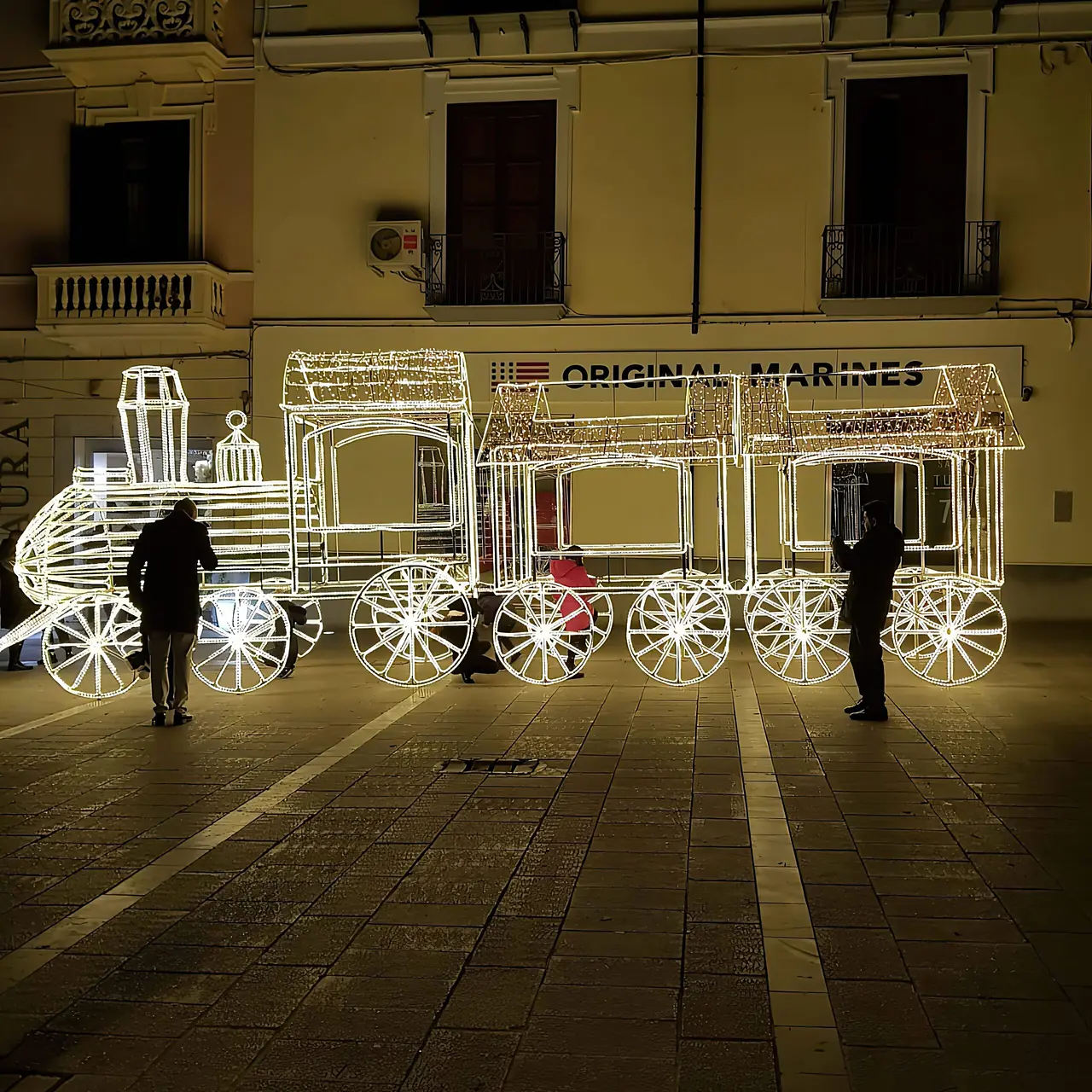 Locomotiva e vagoni di luce bianca in una piazza